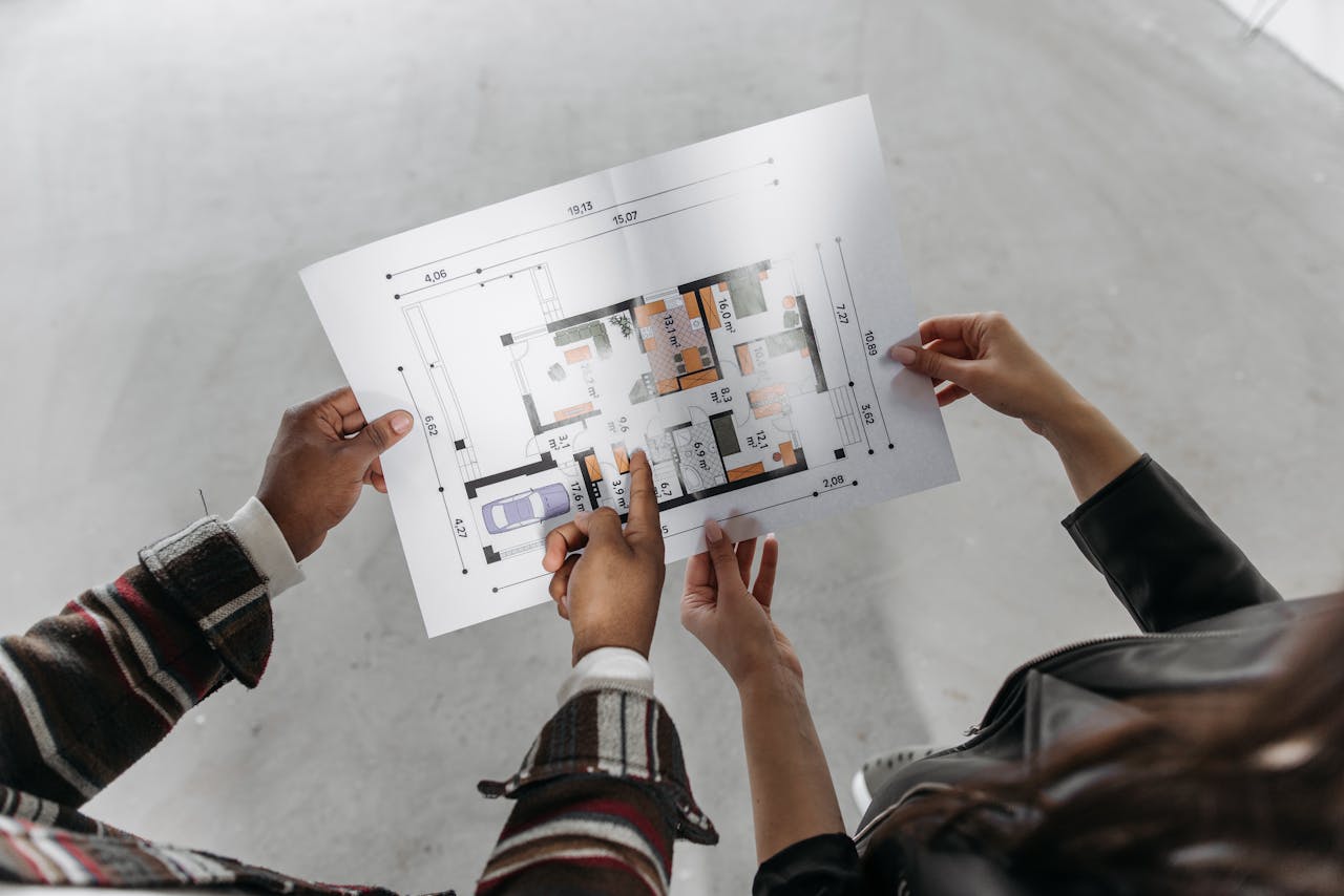 Mastering the First Impression: Your intriguing post title goes here Two people reviewing architectural plans and measuring a new home design.
